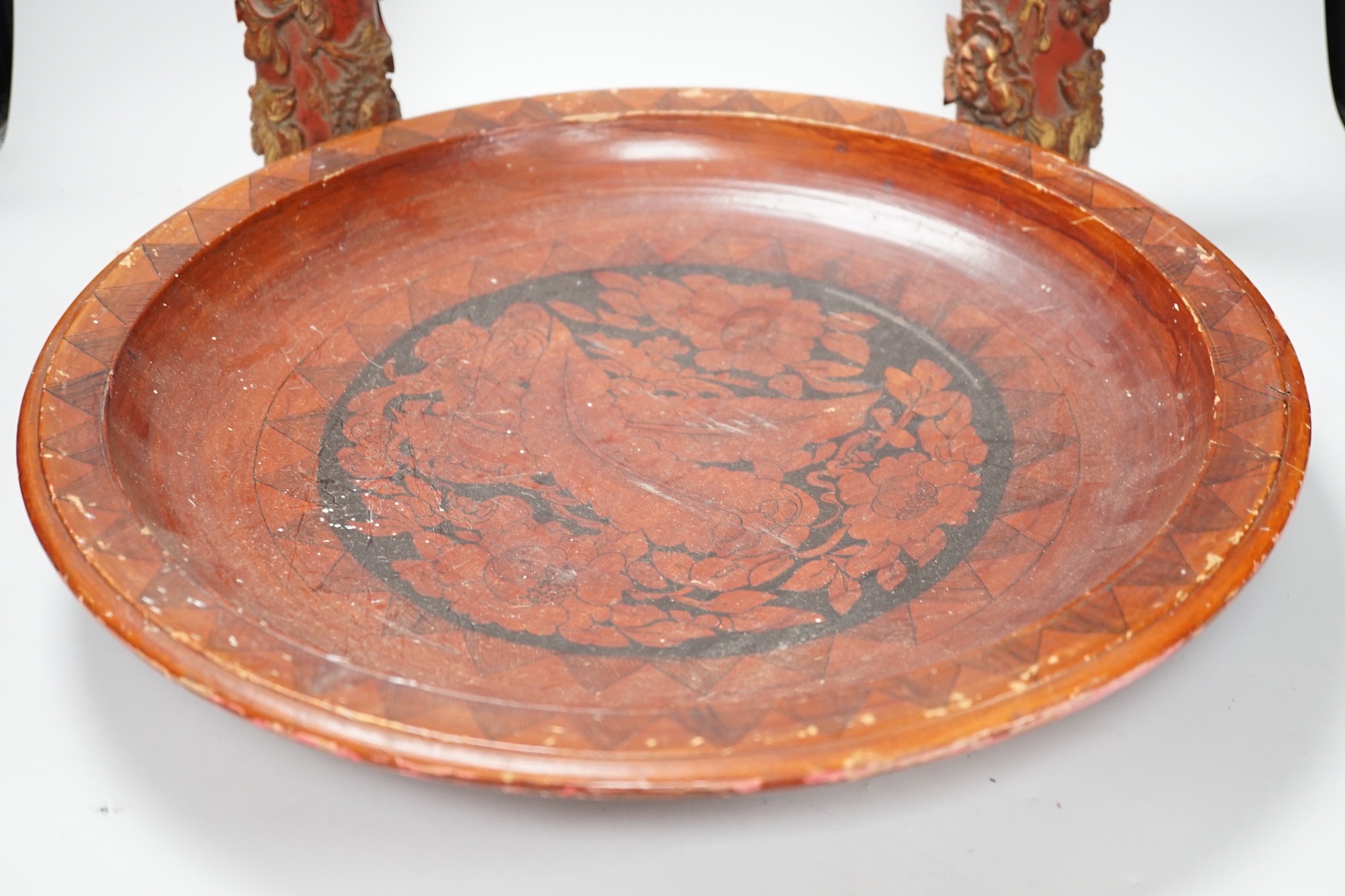 A pair of early 20th century Chinese carved red lacquer and gilt temple incense burners and a similar Asian lacquer dish, dish 44.5cms diameter